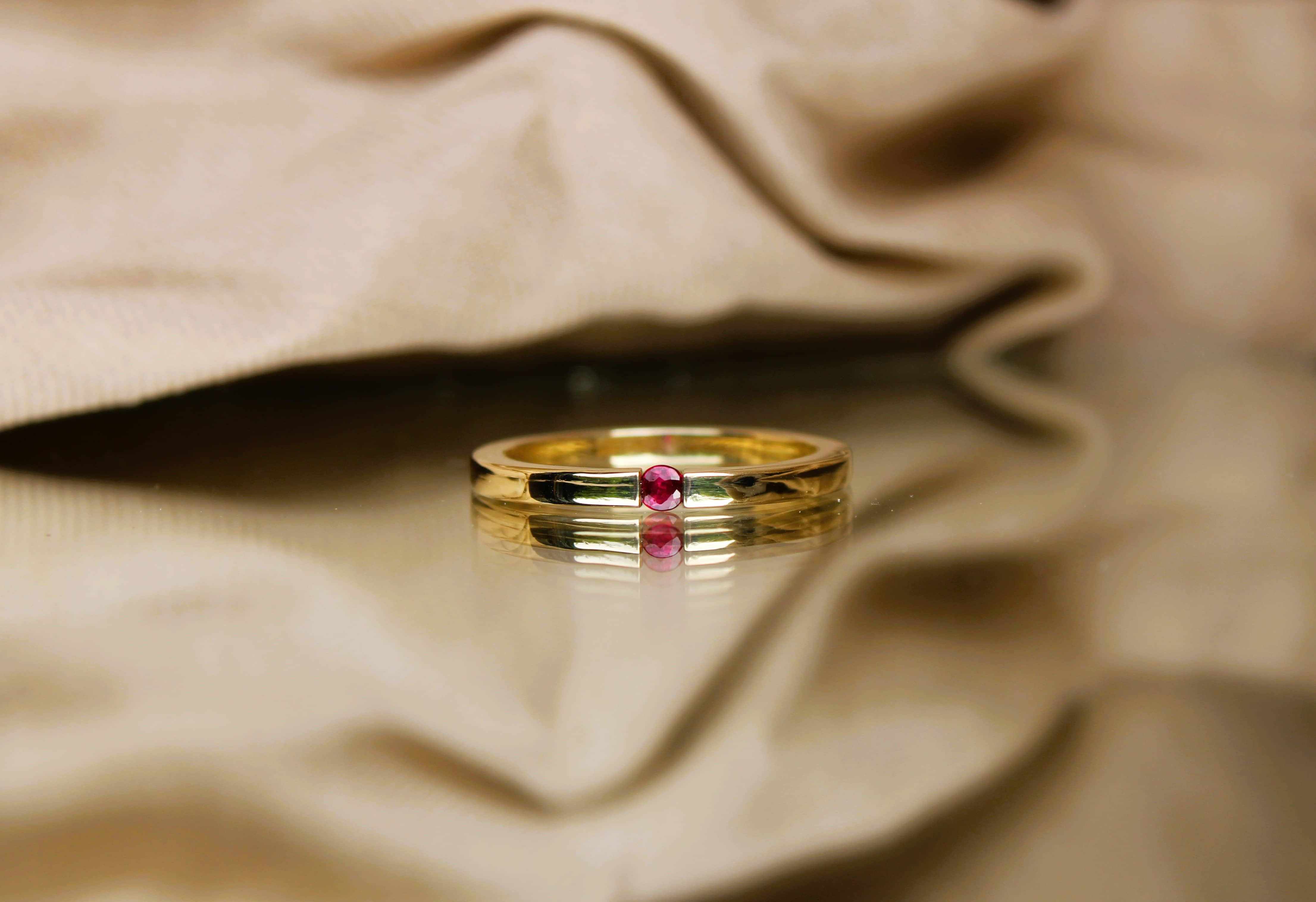 Gouden ring met rode steen op linnen